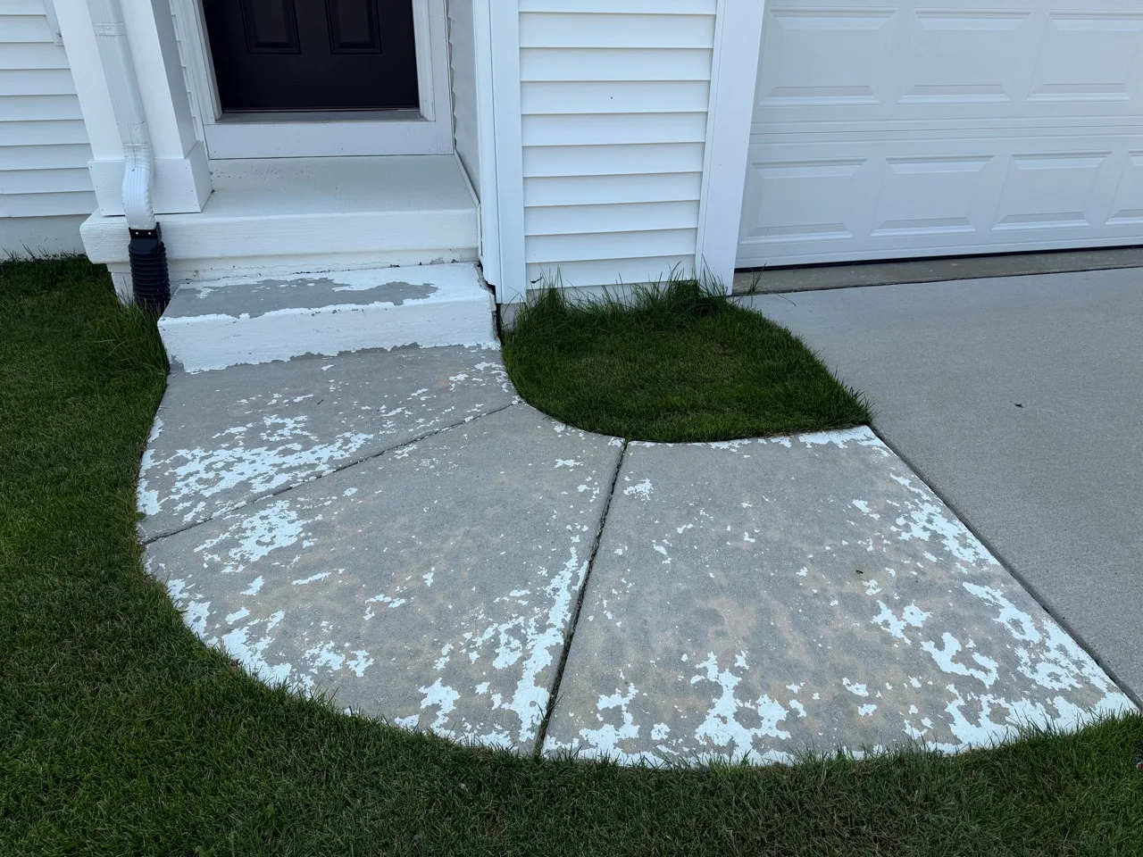 Concrete entry steps and curved walkway with peeling white paint
