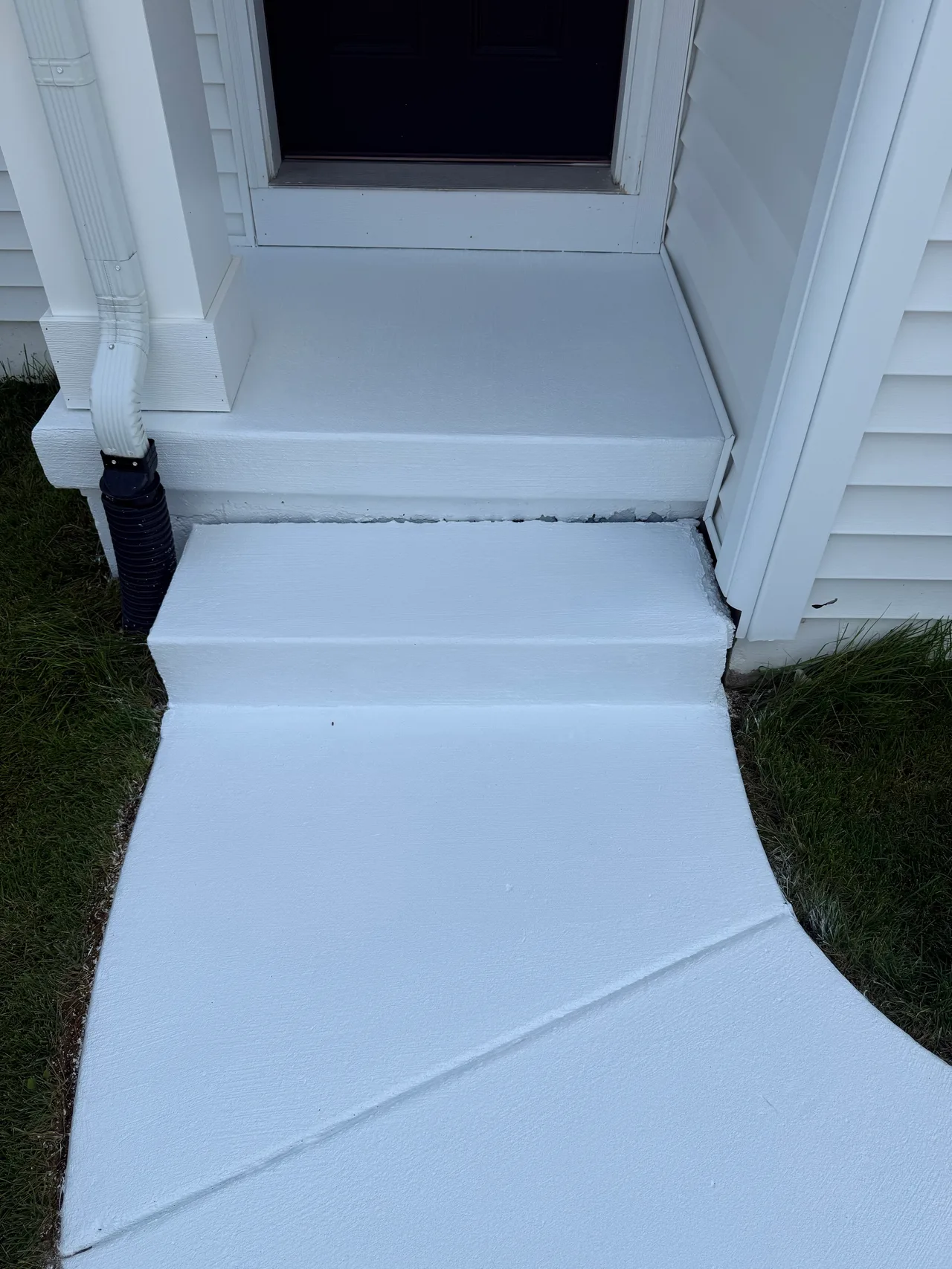 Close view of white-painted concrete entry steps and walkway
