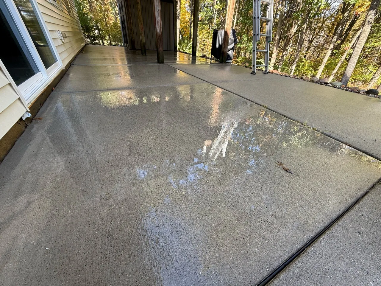 Matching covered patio with a wet, clean concrete surface