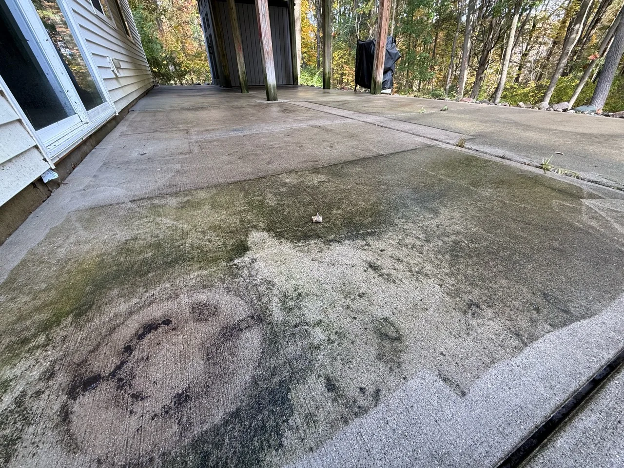 Covered concrete patio with visible green and dark surface buildup