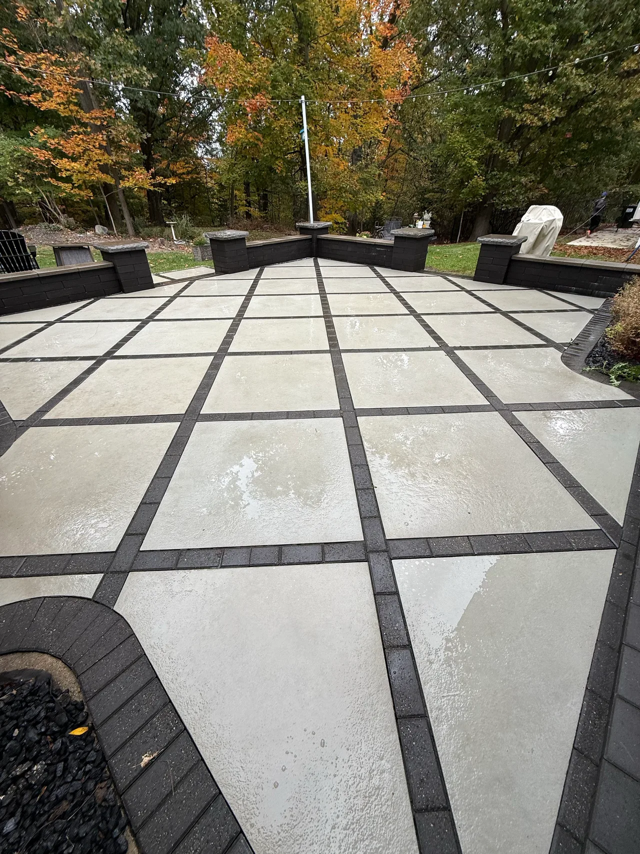 Wet light-colored patio with dark grid borders following cleaning