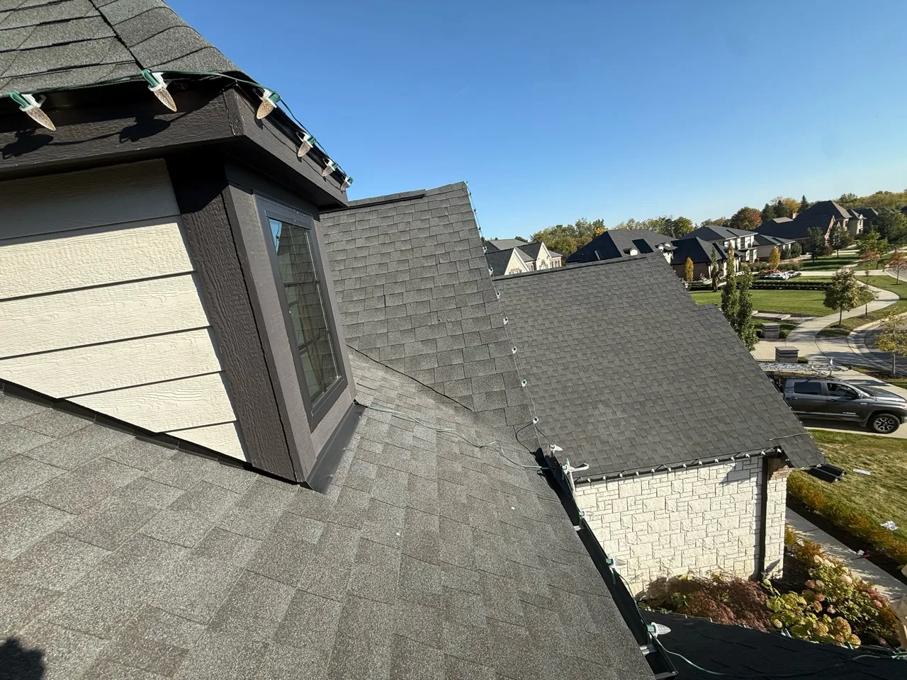 Wide daytime roof view showing holiday lights installed along the edges