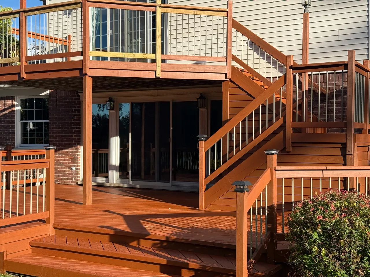 Orange-brown deck boards and stairs with contrasting light rail balusters
