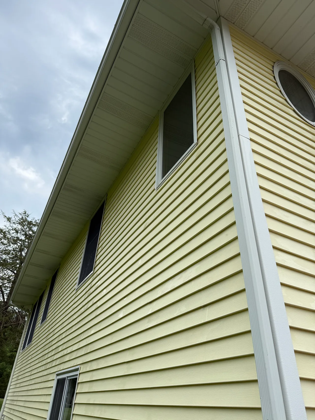 Matching upper vinyl siding with the visible green buildup removed
