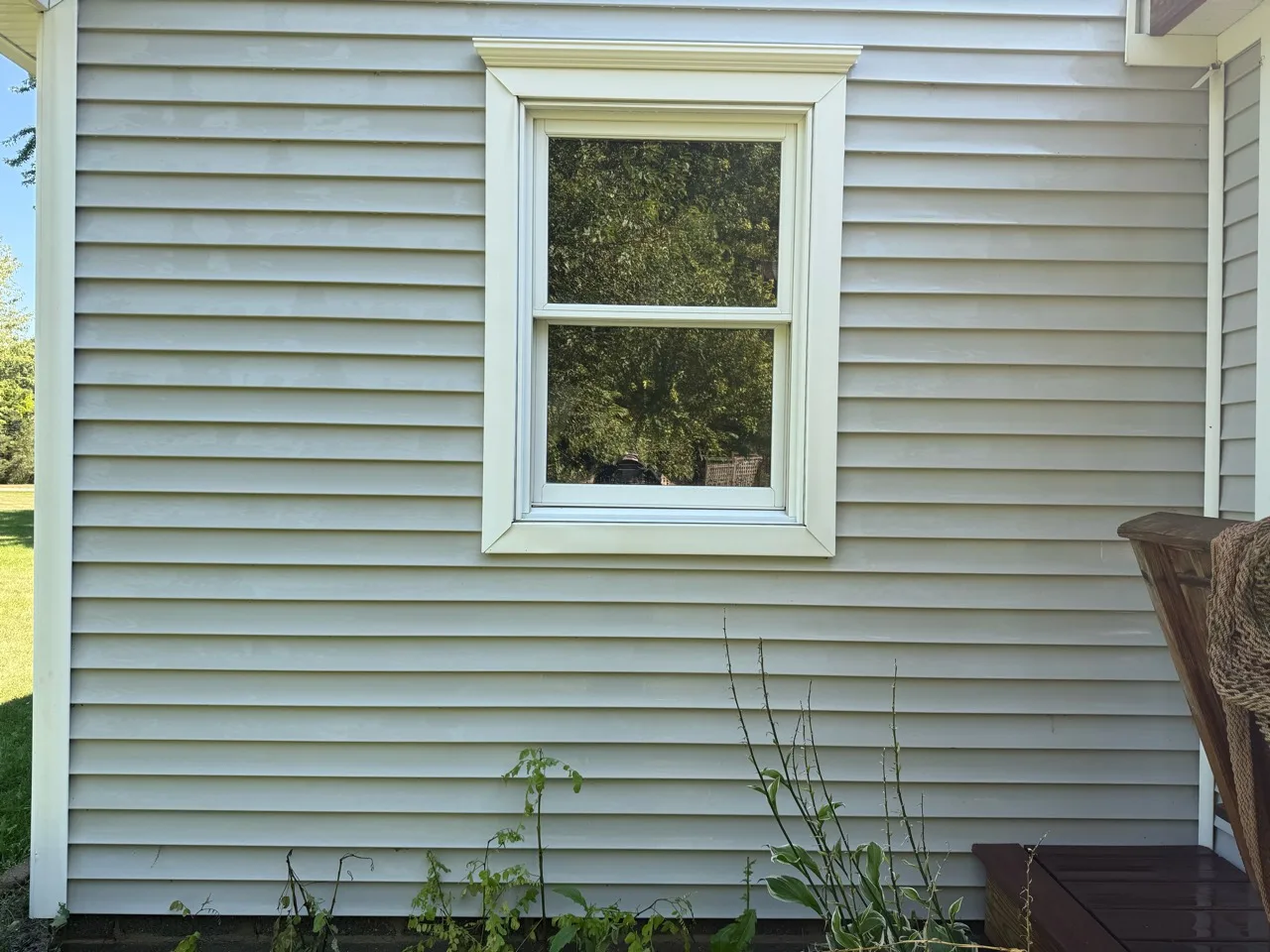 Matching vinyl siding and window trim after the dark surface buildup has been removed